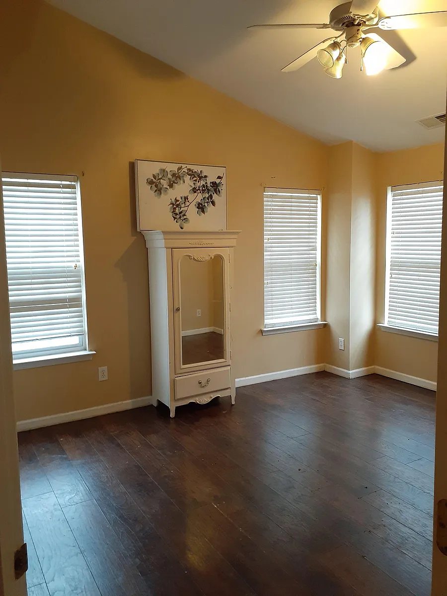 Open room with multiple windows, ceiling fan, and durable wood-look flooringideal for flexible sleeping and desk setup. - Bailey Rd