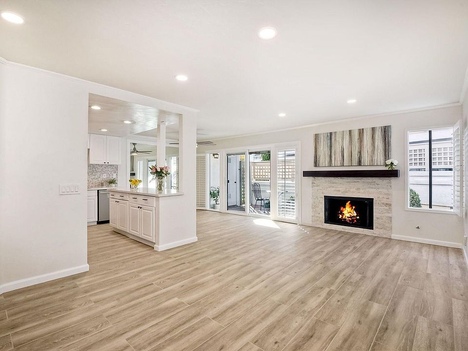 Living room. Gas fireplace. Brand new wood plank looking tile throughout. Sliding glass door exits to a beautifully maintained large private patio.