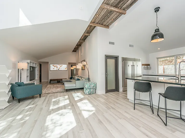 Vaulted great room with exposed beams and chef's kitchen