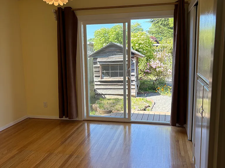 Primary bedroom, hardwood floor, sliding glass door to back deck