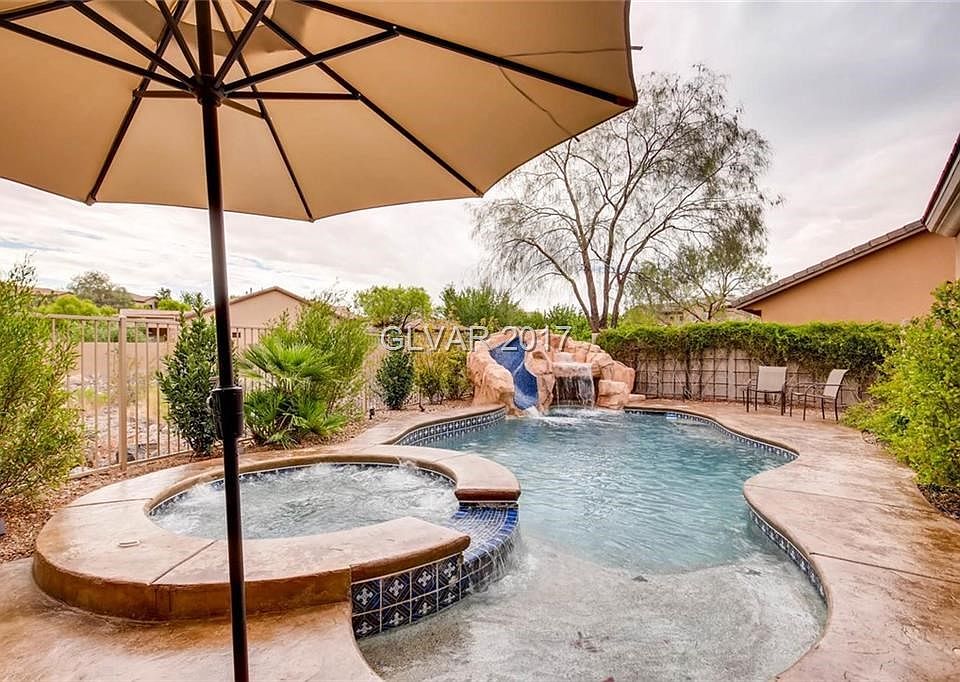 Rock waterfall pool slide! Stamped concrete and lush desert landscape
