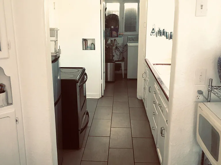 Kitchen with archway facing the laundry room, and the breakfast nook on the opposite end