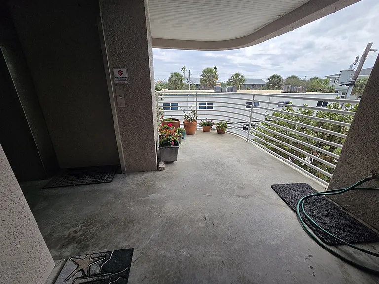 BACK PORCH FACES EAST, ALLEY SEPARATES UNITS FROM APARTMENTS.