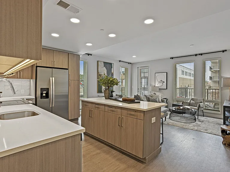 Gourmet Kitchen And Dining Area With White Countertops, Rustic Taupe Cabinets, and Stainless-Steel Appliances