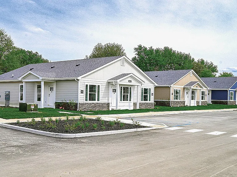 Charming row of modern single-story homes with manicured lawns in a tranquil suburban setting.