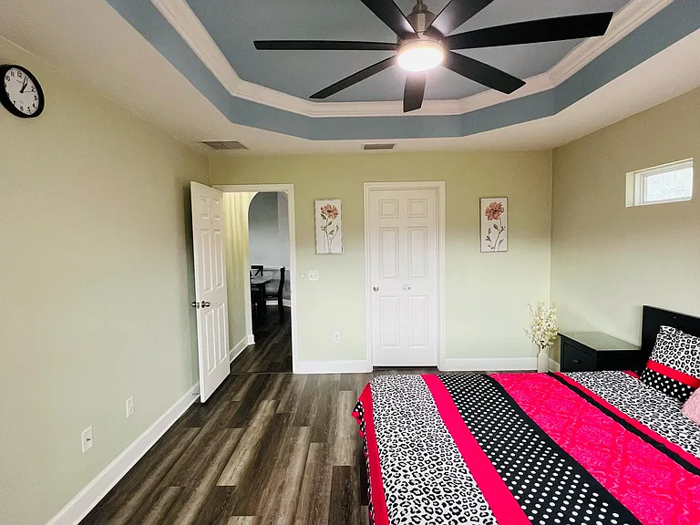 The spacious Master bedroom elegantly designed, with large windows that frame a breathtaking view of lush green landscapes