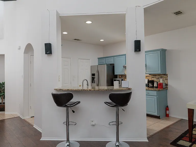 Open kitchen concept with all the major appliances with 2 bar top stools by the pass through. With the washer/dryer in laundry closet.