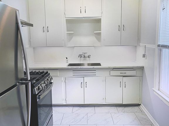 New refrigerator and gas stove and oven, large kitchen sink.