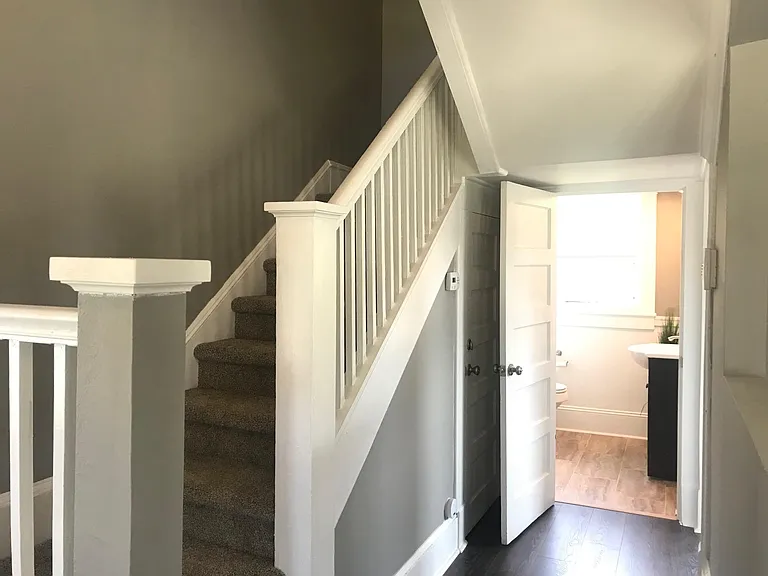 Staircase and first floor bathroom entrance. Carpet has been replaced with wood on stairs.