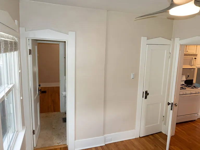 The back bedroom with the bathroom entrance on the left, closet door, and kitchen entrance on the right.