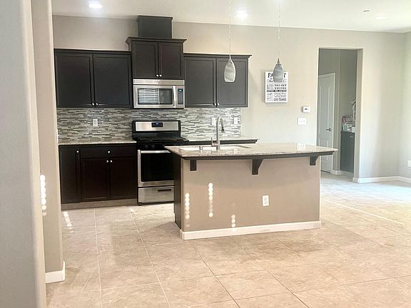 This island is a great spot for having a drink and looking at the beautiful view of the backyard.