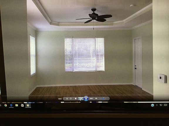 large master bedroom with a wood floor notice the coffered ceilings with fan