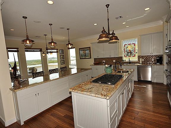 Spacious & Open kitchen w/double islands and nautical lighting.  Gorgeous granite/backsplash selections.  Note the bamboo floors are carried thru the kitchen.