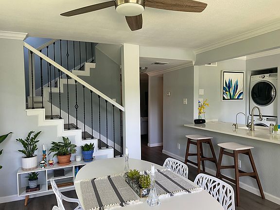 View of dining room and kitchen area with open staircase.