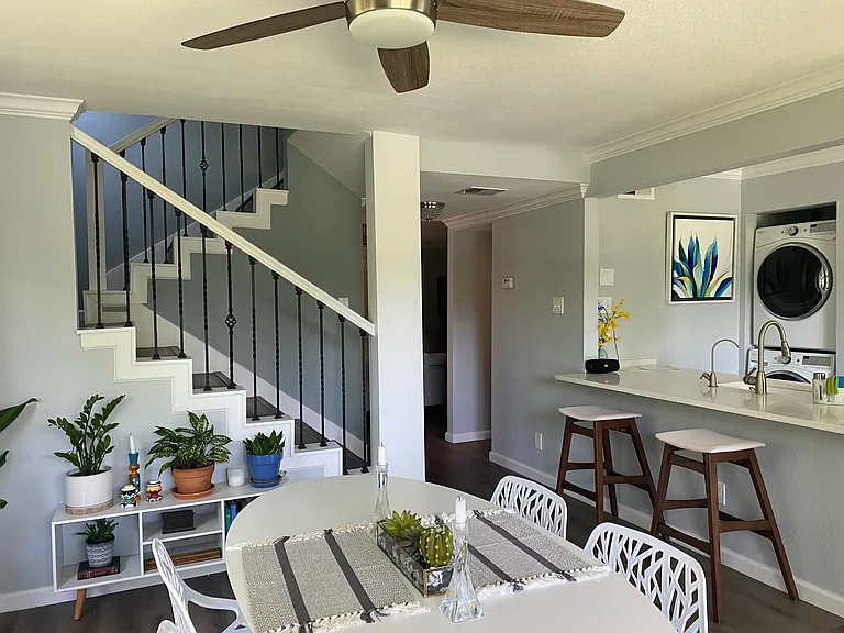 View of dining room and kitchen area with open staircase.