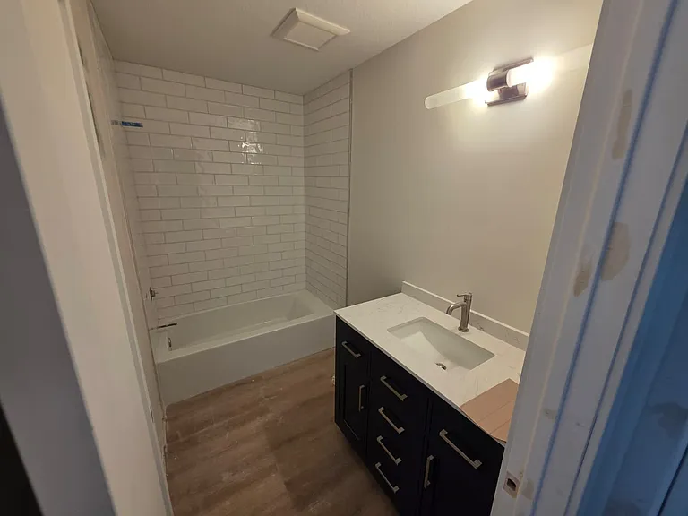 Shared bathroom for the two extra bedrooms. Subway tile shower surround.