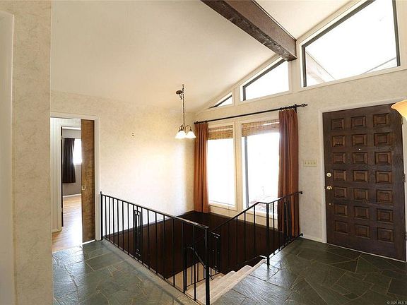 Open and light floor plan with beams from front to back of the home to let in great views and abundant light! Terrazzo marble floors, stairs to finished basement.