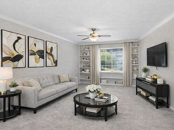 Bright, airy, and beautifully styled, this inviting living space features plush carpeting, soft neutral tones, elegant built-ins, and abundant natural light, creating a warm, modern retreat that feels both spacious and effortlessly comfortable.