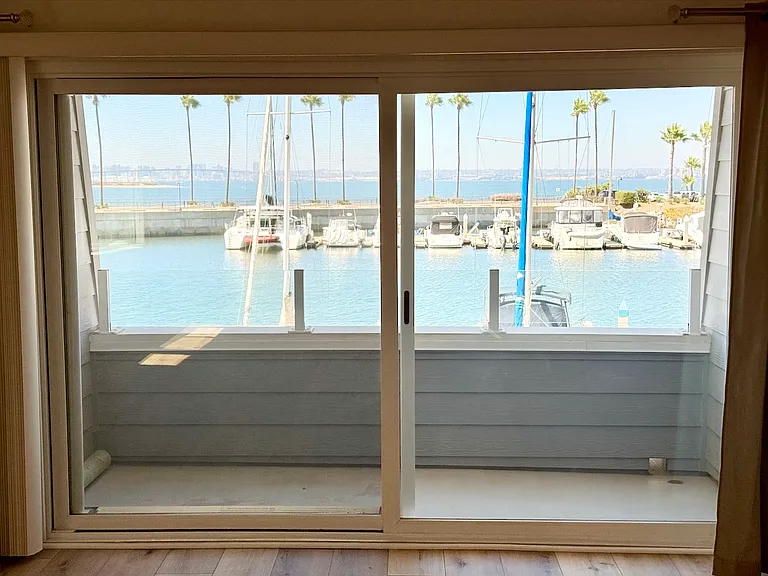 Lower level, living room view through sliding glass door & balcony.