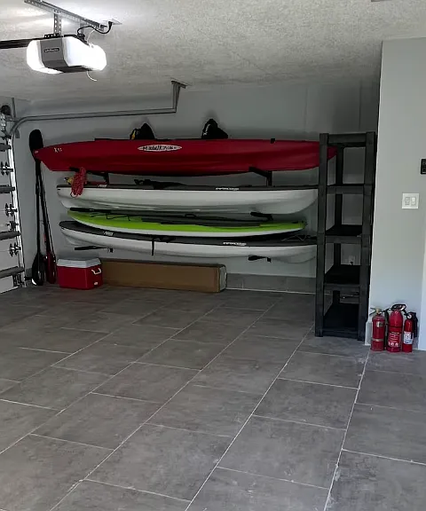 2 car garage with 2 kayaks, 2 paddleboards and a cooler