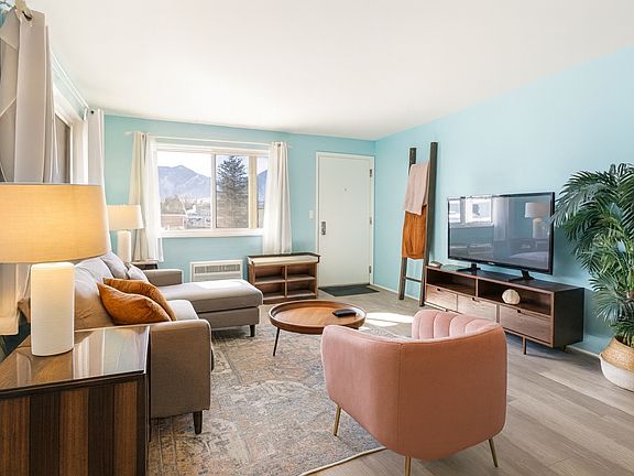 Framed by windows and full of light, this living room offers mountain scenery, soft seating, and all the cozy touches to make you feel right at home.