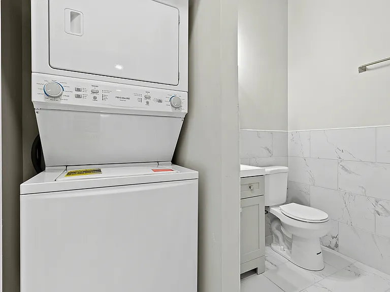 Experience convenience with this compact laundry setup and chic powder room.