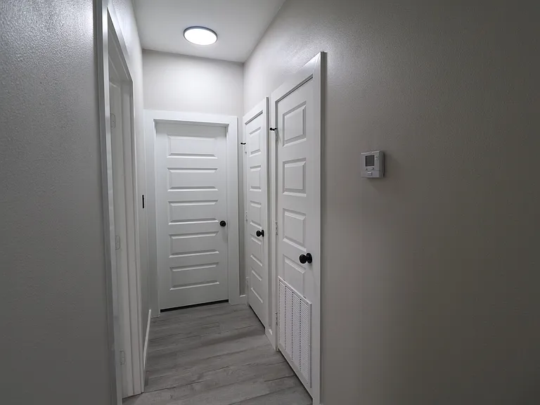 Bright hallway featuring modern flooring, recessed lighting, and clean contemporary finishes.