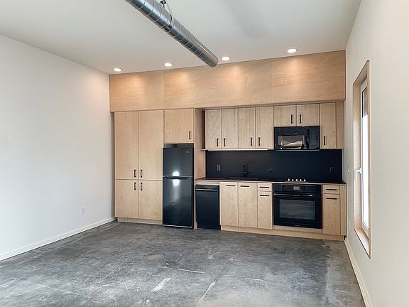 sleek kitchen with high-end cooking appliances, hand-built cabinets and locally sourced materials