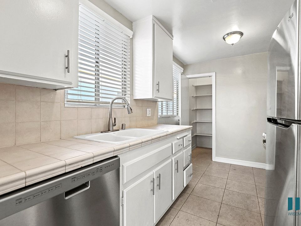 Kitchen with Stainless-Steel Dishwasher, Refrigerator, and Pantry
