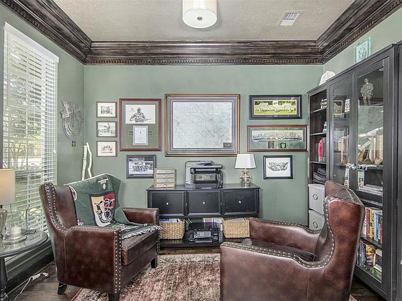 The Study is just off the entry to the left...Here you have the updated rich wood flooring and the owners have stained the Dental Millwork detailed Double Crown Molding match the flooring as well as custom painting the walls.