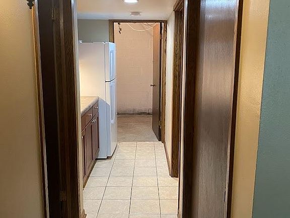 Entry from garage door, off downstairs living room. Bathroom and kitchenette at left, closet and spare room at right, laundry room directly ahead