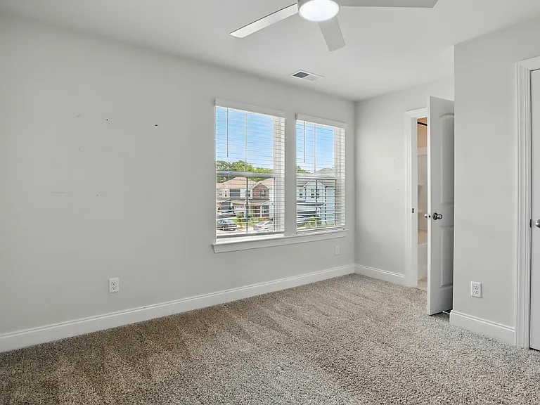 Bedroom 2 - Comfortable second bedroom with neutral finishes and closet space, connected via Jack & Jill bath.
