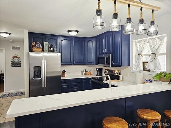 Kitchen with granite countertops and modern lighti
