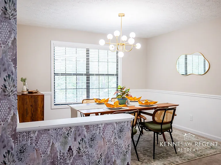 A striking West Elm table serves as the centerpiece, paired with stylish, modern chairs that complement its clean lines.