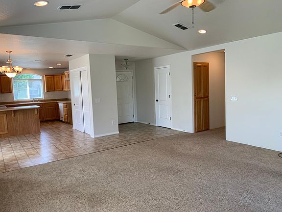 Standing in the living room you see kitchen to the left, front door in center, hallway to 3 bedrooms and laundry room to the right