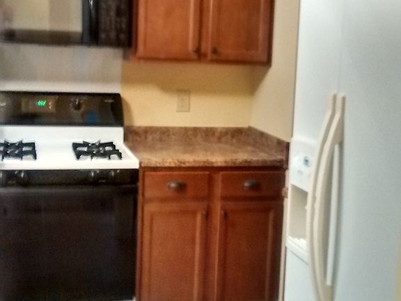 Gas stove with wall microwave.