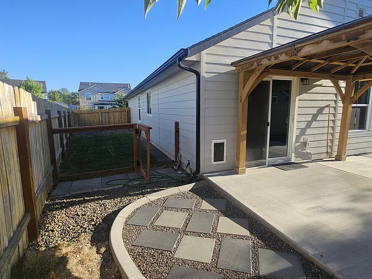 side yard has a fenced area with grass