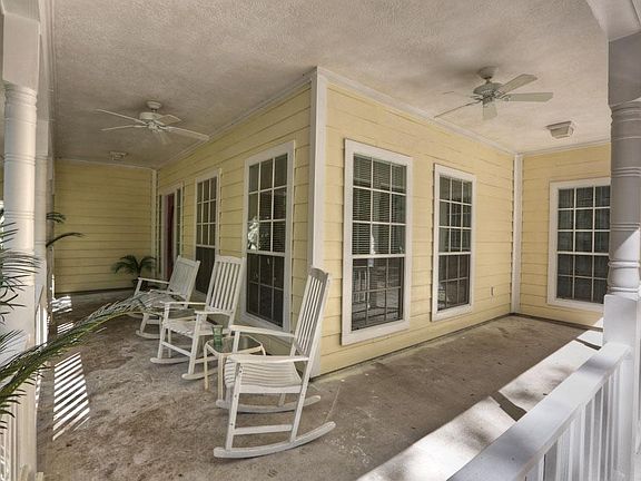 inviting wrap around porch with ceiling fans