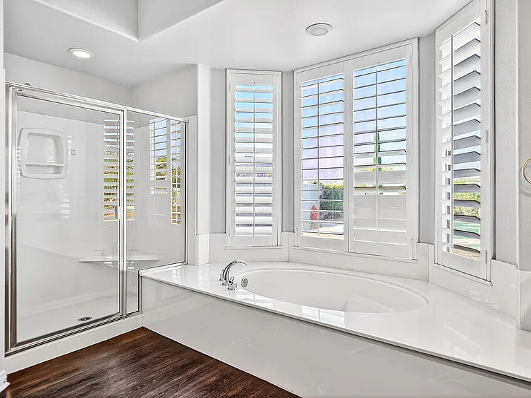 PRIMARY BEDROOM SUITE HAS SOAKING TUB AND SEPARATE SHOWER
