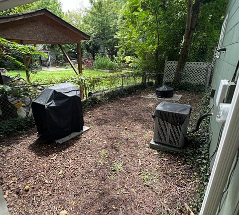fenced backyard area with fire pit, wood/smoker grill provided by landlord