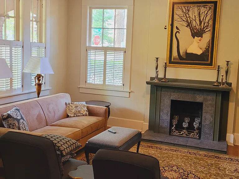 Living room with plantation shutters and lots of natural light in front of house adjacent to entry foyer