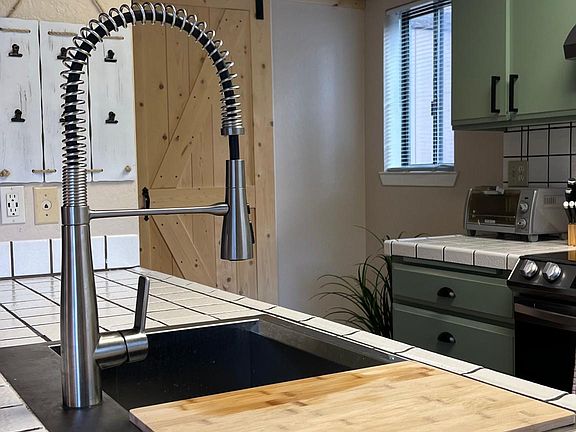 Farmhouse Kohler sink with attached cutting board.