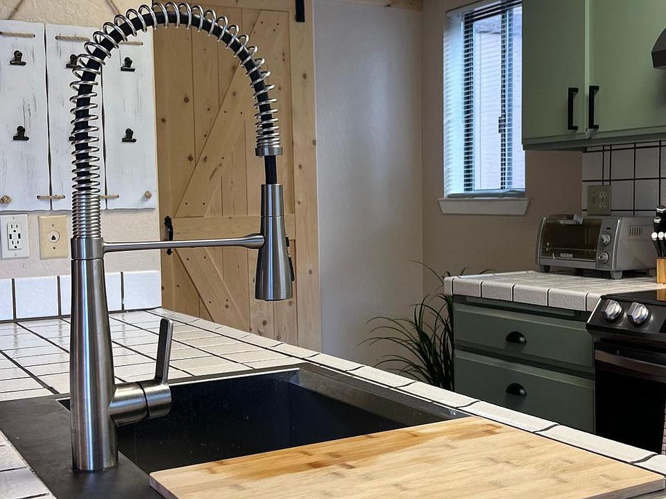Farmhouse Kohler sink with attached cutting board.