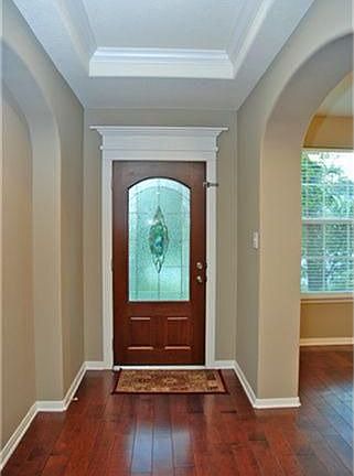 Beautiful foyer with arched doorways, inset ceiling and hardwood floors.