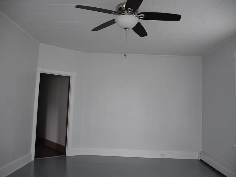 Large living room with ceiling fan, bay windows, cable ready.