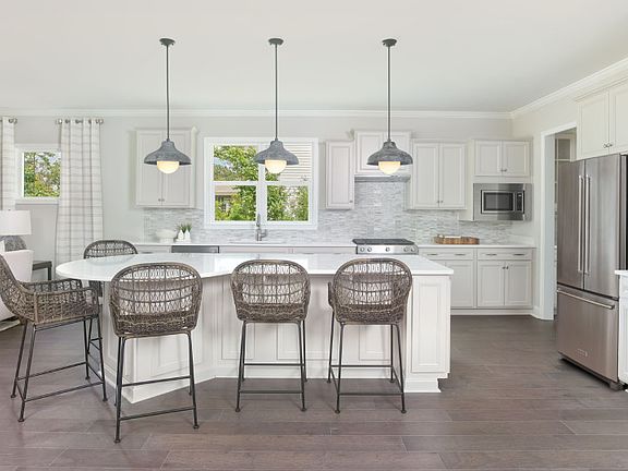 A spacious kitchen with beautiful hardwood floors comes equipped with a large island.