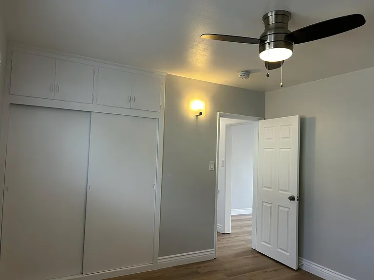 View from inside bedroom of closets, brand new designer laminate floors, ceiling lamp/fan, wood molding and specialty paint.