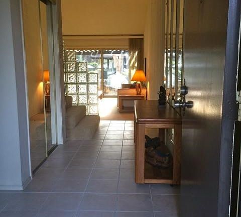 entry way leading to large living room. closet with mirrored, sliding doors on left. hallway immedia