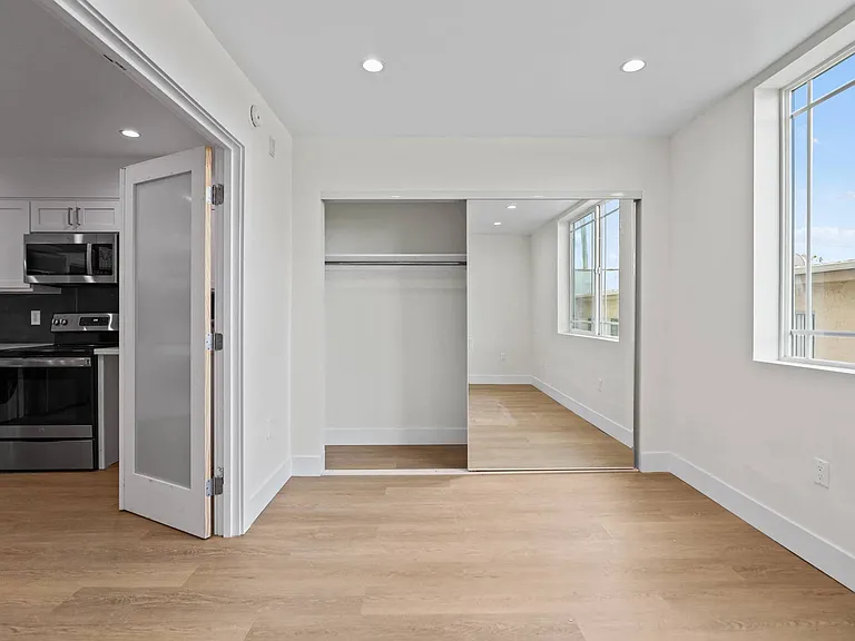 Bedroom with Mirrored Closet, Recessed Lighting, and Double Windows
