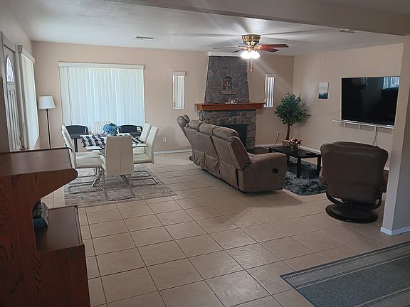 Open living room/dining area. Large 75" tv. New couch with dual recliners, along with 2 separate recliners